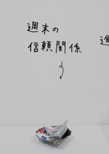 牛島光太郎の作品『組み合わせの方法』。日用品を組み合わせたモノと壁に油性ペンで言葉(文字)を書いた作品。