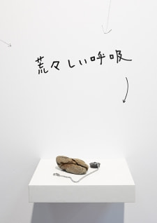 牛島光太郎の作品『組み合わせの方法』。日用品を組み合わせたモノと壁に油性ペンで言葉(文字)を書いた作品。