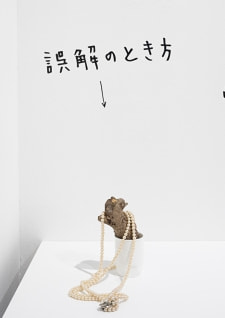 牛島光太郎の作品『組み合わせの方法』。日用品を組み合わせたモノと壁に油性ペンで言葉(文字)を書いた作品。