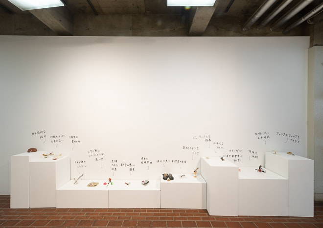 牛島光太郎の作品『組み合せの方法』。日用品を組み合わせたモノと壁に油性ペンで言葉(文字)を書いた作品。