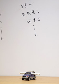 牛島光太郎の作品『組み合わせの方法』。日用品を組み合わせたモノと壁に油性ペンで言葉(文字)を書いた作品。