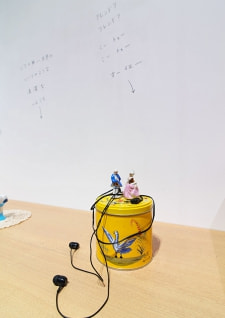 牛島光太郎の作品『組み合わせの方法』。日用品を組み合わせたモノと壁に油性ペンで言葉(文字)を書いた作品。