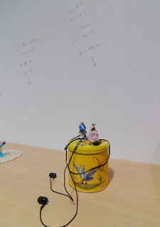 牛島光太郎の作品『組み合わせの方法』。日用品を組み合わせたモノと壁に油性ペンで言葉(文字)を書いた作品。