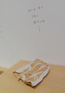 牛島光太郎の作品『組み合わせの方法』。日用品を組み合わせたモノと壁に油性ペンで言葉(文字)を書いた作品。